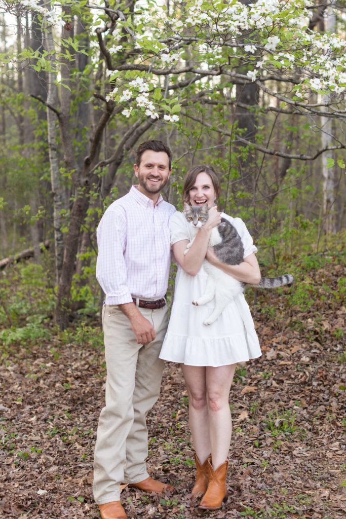 couple smiling and holding cat
